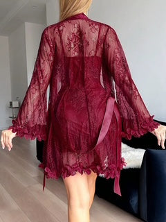 Person wearing a burgundy lace robe in a room with a neutral color scheme.