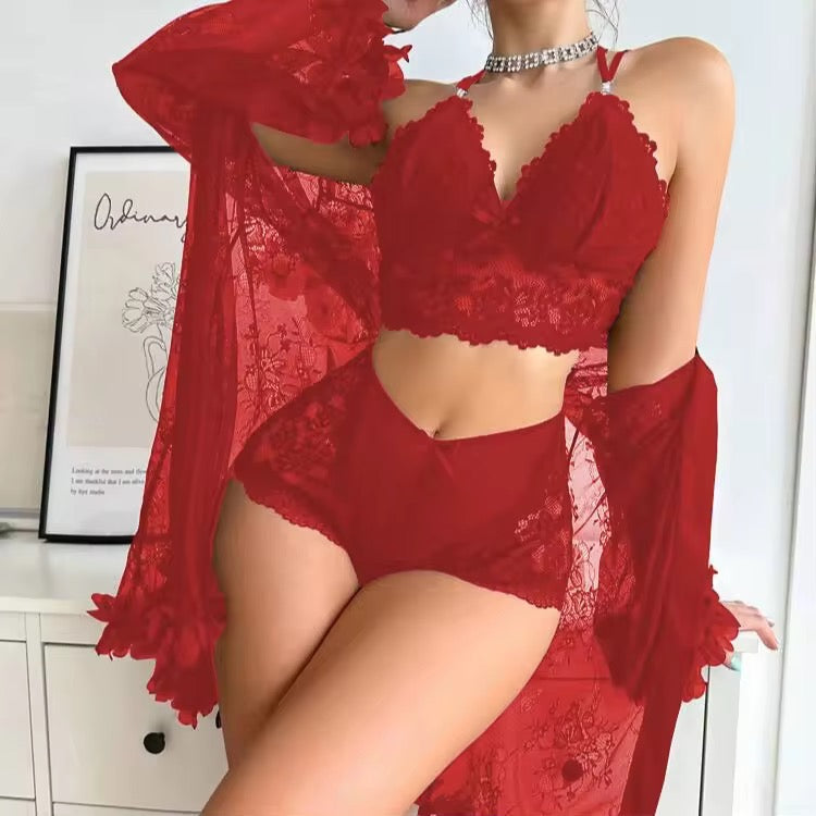 Person wearing a red lace lingerie set with a sheer cover-up in a room setting.