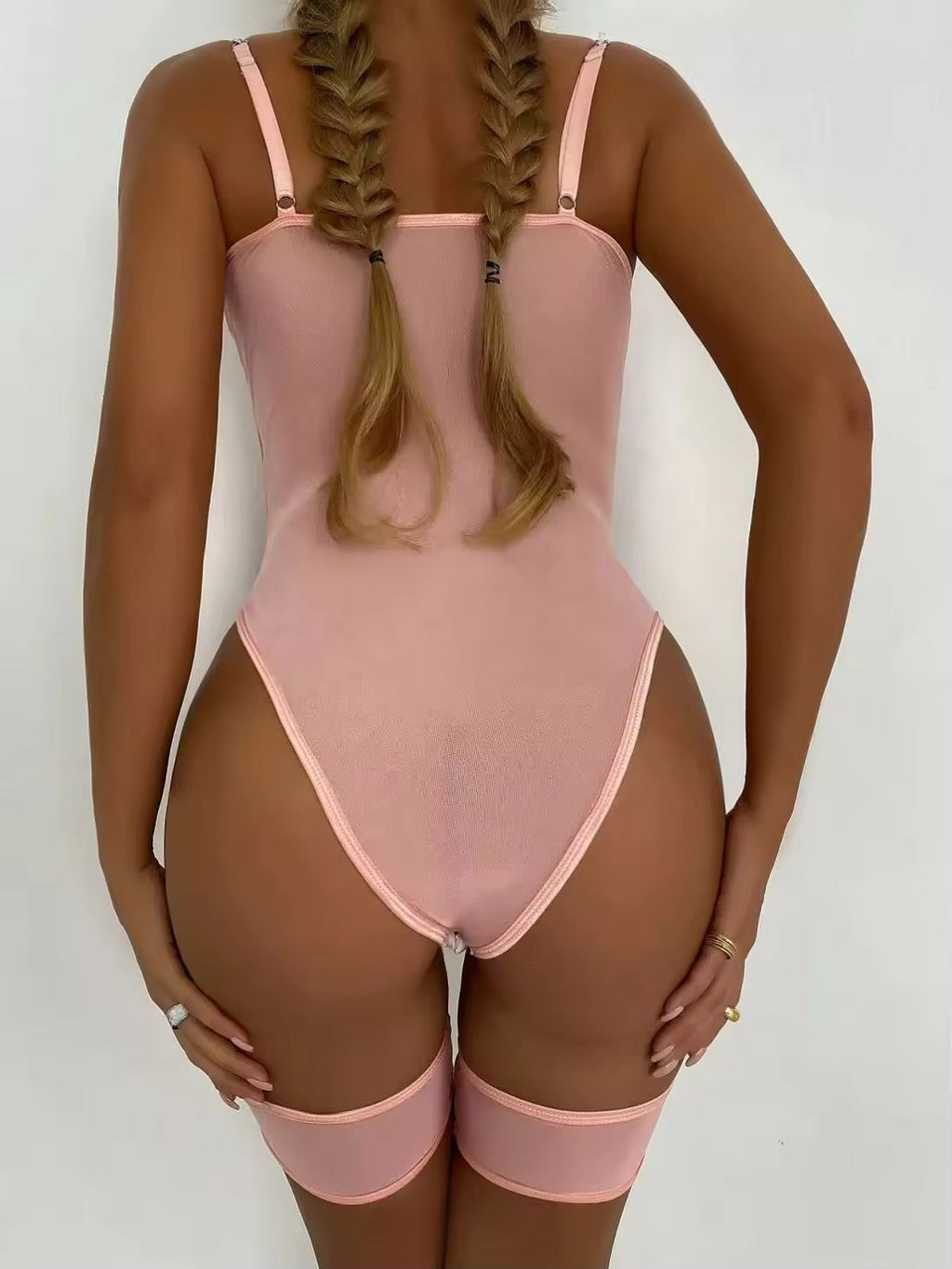 Person wearing a pink bodysuit against a white background