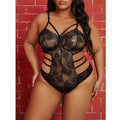 Person wearing a black lace lingerie set against a red brick wall.