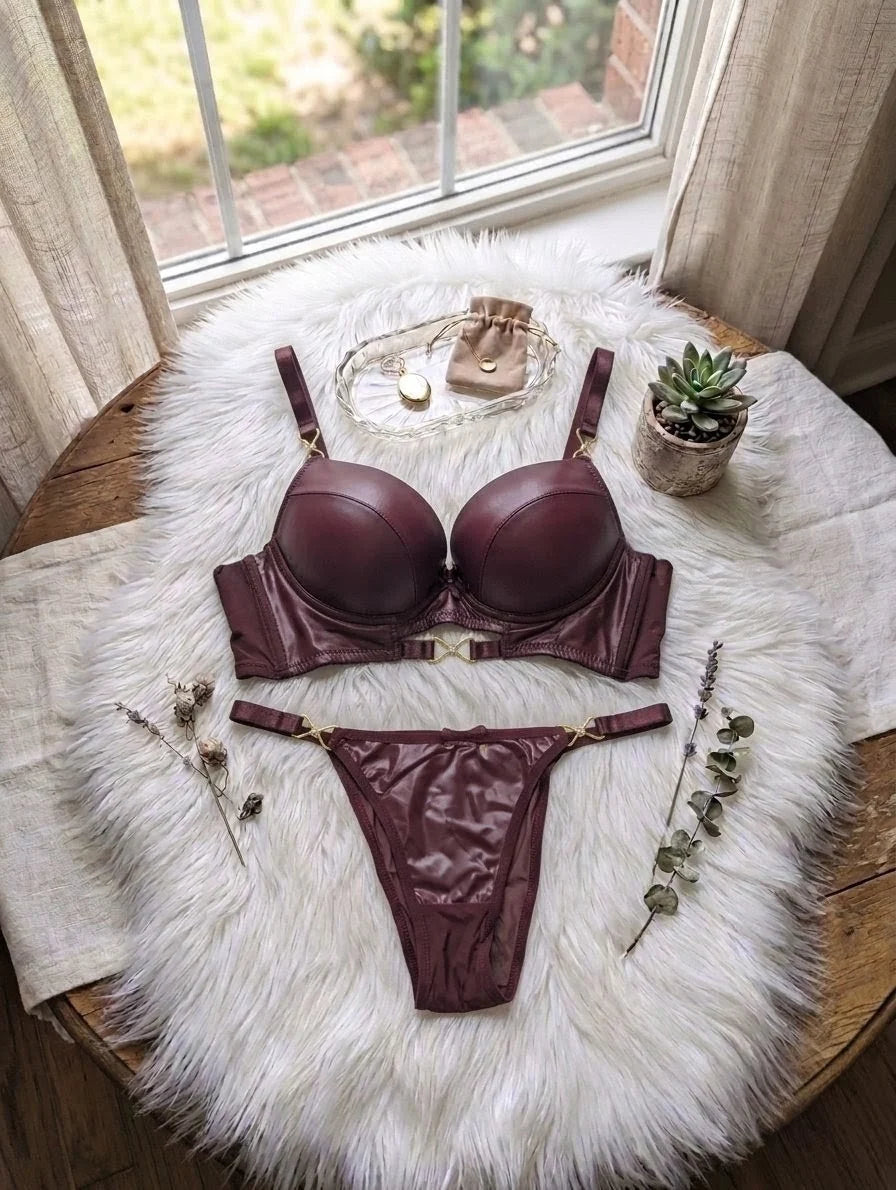 Burgundy lingerie set on a fluffy white rug with a window in the background