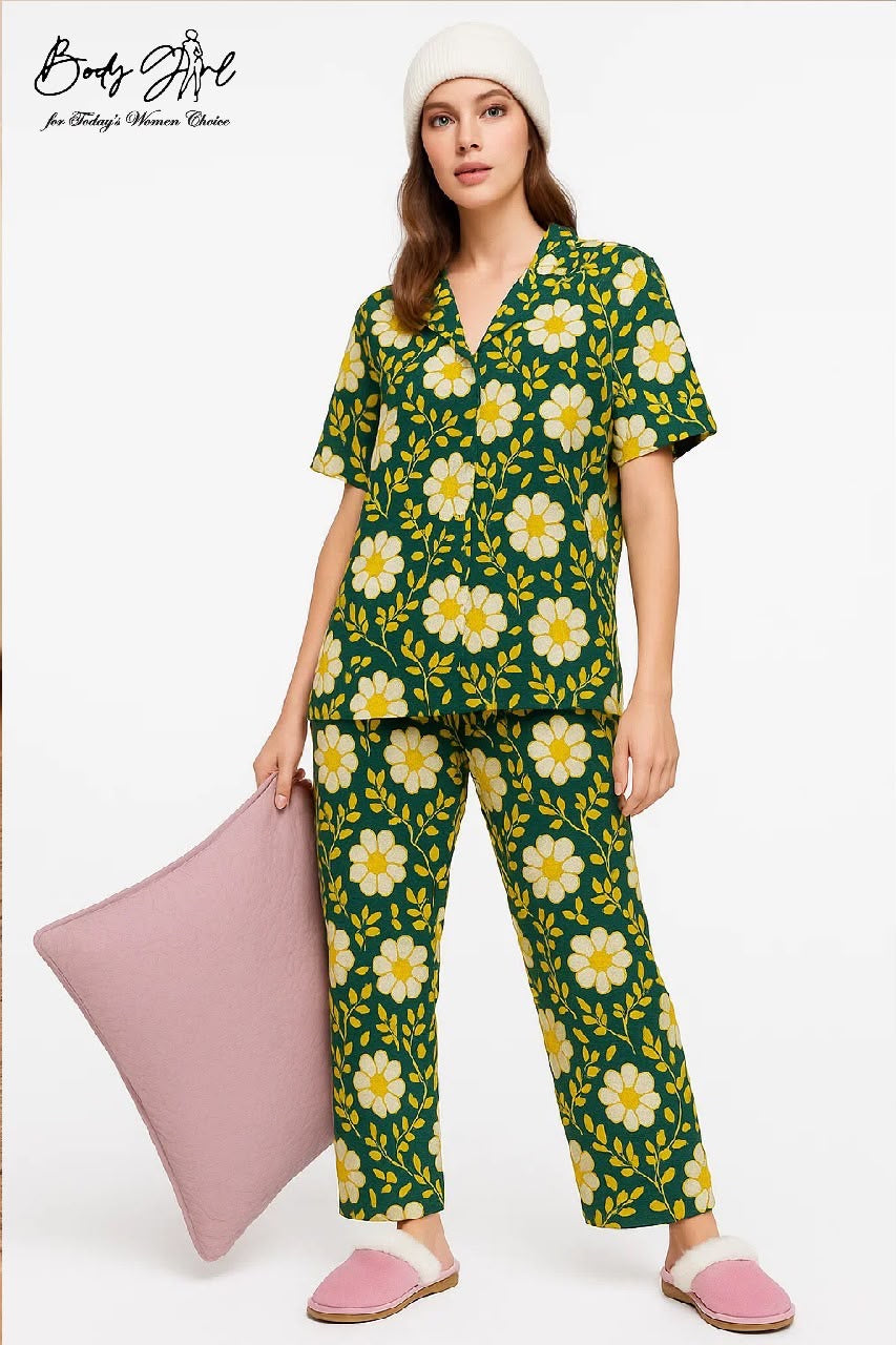 Woman wearing a green floral pajama set with a white pillow on a white background